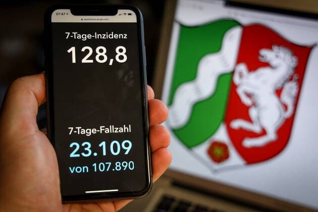 Coronavirus in Germany Covid 19 Dashboard of the Robert Koch Institute DEU, Germany, North Rhine Westphalia, 28 03 2021 The 7-day incidence for the state Cases last 7 days 100 000 p.e. is displayed on an iPhone, with the state coat of arms in the background