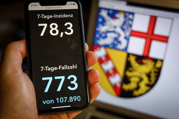 Coronavirus in Germany Covid 19 Dashboard of the Robert Koch Institute DEU, Germany, Saarland, 28 03 2021 The 7-day incidence for the state Cases last 7 days 100 000 PE is displayed on an iPhone, with the state coat of arms in the background