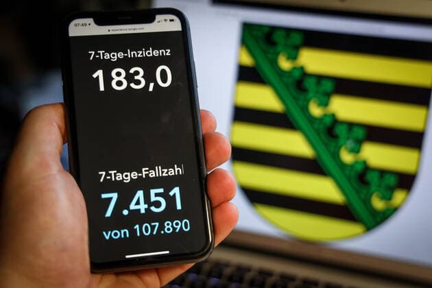 Coronavirus in Germany Covid 19 Dashboard of the Robert Koch Institute DEU, Germany, Saxony, 28 03 2021 The 7-day incidence for the state Cases last 7 days 100 000 p.e. is displayed on an iPhone, with the state coat of arms in the background