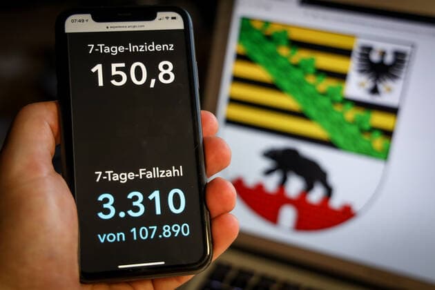 Coronavirus in Germany Covid 19 Dashboard of the Robert Koch Institute DEU, Germany, Saxony Anhalt, 28 03 2021 The 7-day incidence for the state Cases last 7 days 100 000 p.e. is displayed on an iPhone, with the state coat of arms in the background