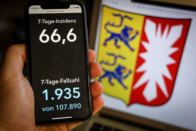 Coronavirus in Germany Covid 19 Dashboard of the Robert Koch Institute DEU, Germany, Schleswig Holstein, 28 03 2021 The 7-day incidence for the state Cases last 7 days 100 000 p.e. is displayed on an iPhone, with the state coat of arms in the background