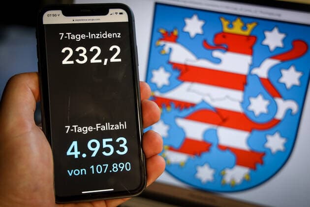Coronavirus in Germany Covid 19 Dashboard of the Robert Koch Institute DEU, Germany, Thuringia, 28 03 2021 The 7-day incidence for the state Cases last 7 days 100 000 p.e. is displayed on an iPhone, with the state coat of arms in the background
