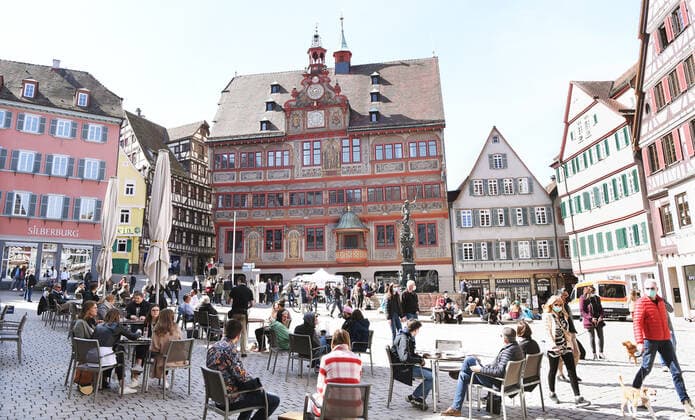 Tuebingen 28 03 2021 Sunday noon in the sun at the cafe on Tuebingens market square With a day certificate day ticket in the form of a wristband with QR code visitors may use the offer The band is given to all tested people at the rapid test station in the background the station at the town hall in the city center ULMER