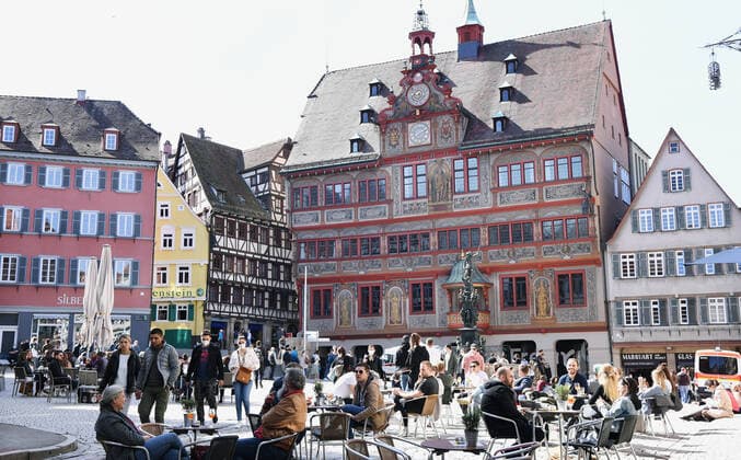 Tuebingen 28 03 2021 Sunday noon in the sun at the cafe on Tuebingens market square With a day certificate day ticket in the form of a wristband with QR code visitors may use the offer The band is given to all tested people at the rapid test station in the background the station at the town hall in the city center ULMER