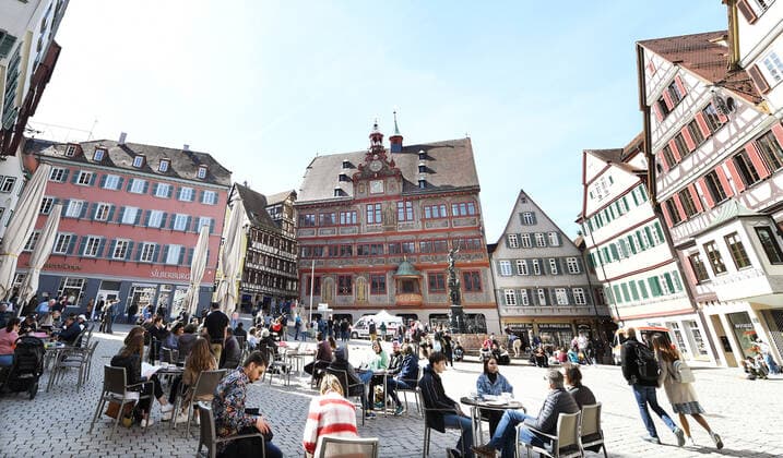 Tuebingen 28 03 2021 Sunday noon in the sun at the cafe on Tuebingens market square With a day certificate day ticket in the form of a wristband with QR code visitors may use the offer The band is given to all tested people at the rapid test station in the background the station at the town hall in the city center ULMER