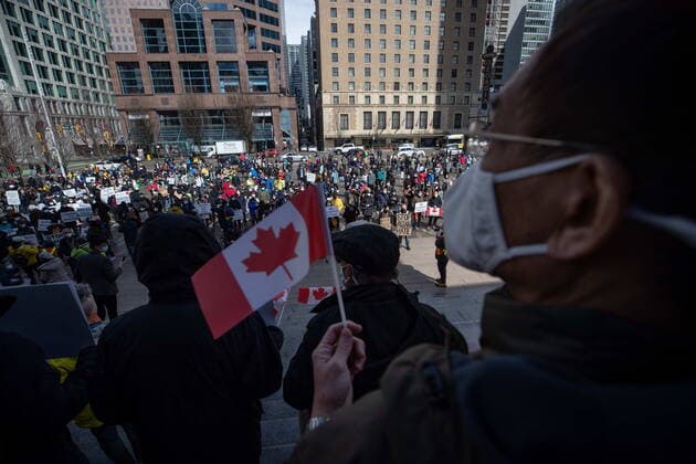 March 28, 2021, Vancouver, BC, Canada: A man holds a Canadian flag as hundreds of people gather for a rally opposing discrimination against Asian communities and to mourn the victims of those affected by the Atlanta shootings, in Vancouver, B.C., on Sunday, March 28, 2021. Vancouver Canada  - ZUMAc35_ 20210328_zaf_c35_113 Copyright: xDarrylxDyckx
