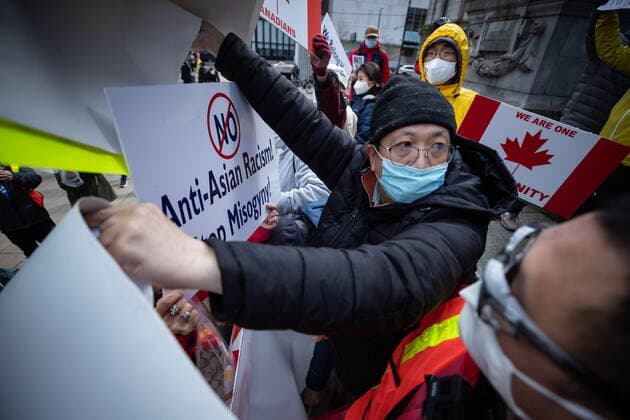 March 28, 2021, Vancouver, BC, Canada: A man who was holding a sign that said Hold CCP Liable is confronted after disrupting a peaceful rally opposing discrimination against Asian communities and to mourn the victims of those affected by the Atlanta shootings, in Vancouver, B.C., on Sunday, March 28, 2021. After a brief scuffle the man was escorted to an area away from the crowd by police. Vancouver Canada  - ZUMAc35_ 20210328_zaf_c35_141 Copyright: xDarrylxDyckx