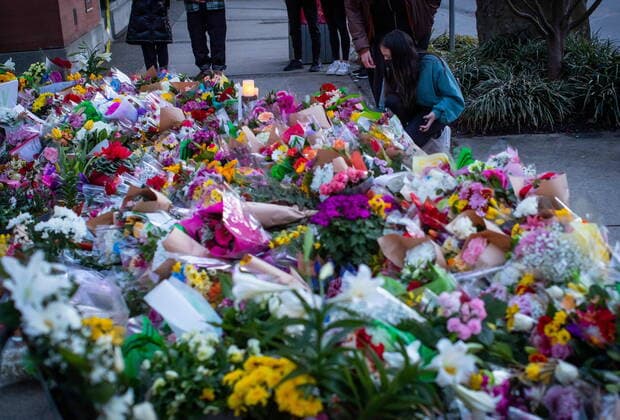 March 28, 2021, Vancouver, BC, Canada: A woman places flowers at a memorial outside the Lynn Valley Library for the victims of a mass stabbing incident that happened Saturday inside and around the library, in North Vancouver, B.C., on Sunday, March 28, 2021. A 28-year-old man was charged Sunday with second-degree murder in a stabbing rampage that left a young woman dead and injured six others around a library in North Vancouver on Saturday. Vancouver Canada  - ZUMAc35_ 20210328_zaf_c35_156 Copyright: xDarrylxDyckx