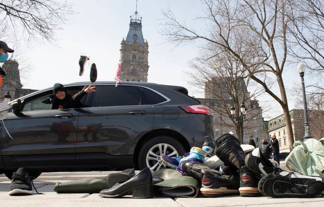 March 30, 2021, QUEBEC, PQ, Canada: An SCFP union worker throws a pair of shoes in front of the National Assembly as demonstrators drive around in their cars, Tuesday, March 30, 2021 in Quebec City. Union workers claim negotiations are at a standstill and give it as the reason to drop shoes. QUEBEC Canada  - ZUMAc35_ 20210330_zaf_c35_026 Copyright: xJacquesxBoissinotx