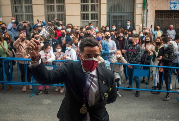 News Themen der Woche KW13 Bilder des Jahres 2021, News 03 März March 30, 2021, Malaga, Spain: A believer wearing a face mask is seen rustling a small bell outside Rescate brotherhood, as part of the Holy Week Worship..Despite cancellation of the processions for the Holy Week, many brotherhood have decided to organize masses, worships and exhibit figures of Christ and the Virgin inside churches or brotherhoods ensuring all protective measures against Covid19 are followed. Malaga Spain - ZUMAs197 20210330_zaa_s197_048 Copyright: xJesusxMeridax