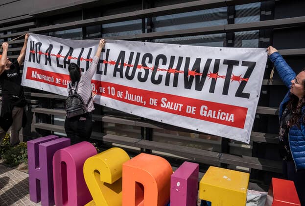 March 31, 2021, Barcelona, Catalonia, Spain: Protesters hang up a banner against Law 8 2008 approved by the Galician Parliament regulating health rights and obligations known as the Auschwitz Law during the demonstration..Summoned by the platform against the obligation of sanitary masks in minors, El Tercer Grupo, some fifty people have gathered at the doors of the Sant Joan De Deu Children s Hospital to protest the call of the hospital to carry out tests of the covid 19 vaccine on minors. Barcelona Spain - ZUMAs197 20210331_zaa_s197_053 Copyright: xPacoxFreirex