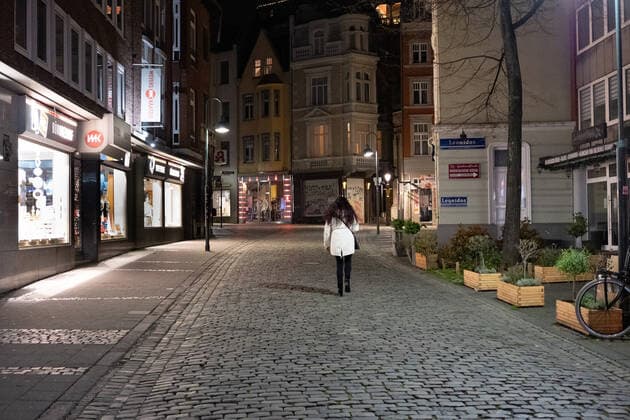 Like an abandoned city. Aachen on Easter vigil between 10 p.m. and 11 p.m. View into the deserted Kleinmarschierstrasse. A single woman walks through the pedestrian zone. In Aachen on April 3, 2021. GERMANY - AACHEN - EASTER Easter 2021 Covid Pandemic