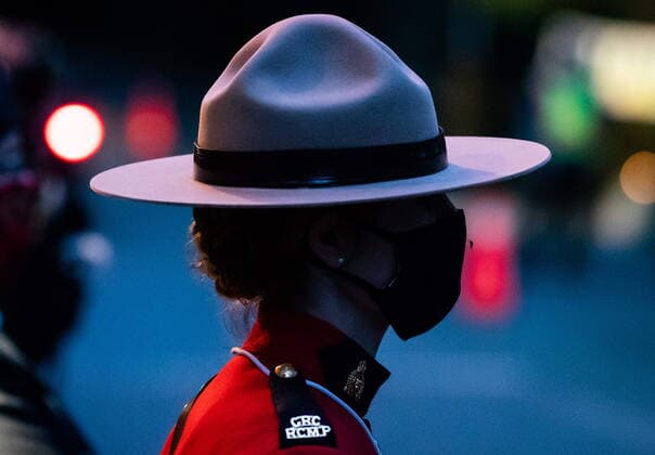 April 3, 2021, North Vancouver, BC, Canada: A mosquito clings to an RCMP officer s face mask as she stands as part of a colour party during a drive-thru candlelight vigil for the victims of last week s mass stabbing incident in and around the Lynn Valley Library, at Lynn Canyon Park in North Vancouver, B.C., on Saturday, April 3, 2021. North Vancouver Canada  - ZUMAc35_ 20210403_zaf_c35_090 Copyright: xDarrylxDyckx