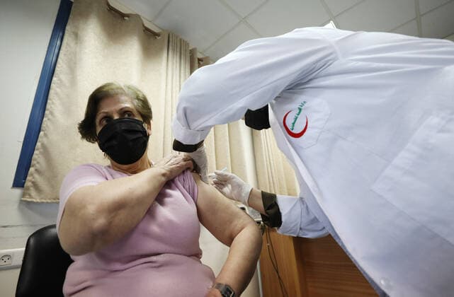 (210404) -- NABLUS, April 4, 2021 -- A woman receives a dose of Sinopharm COVID-19 vaccine during a vaccination campaign in the West Bank city of Nablus, April 4, 2021. China on March 29 handed over a batch of donated Sinopharm COVID-19 vaccines to Palestine to support its nationwide fight against the pandemic. (Photo by Xinhua) MIDEAST-NABLUS-SINOPHARM-COVID-19-VACCINATION AymanxNobani 