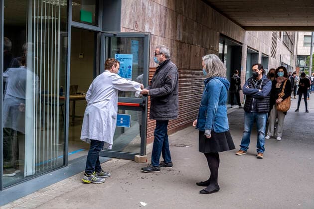 April 4, 2021, Barcelona, Spain: A health worker is seen at the vaccination point of the Faculty of Geography and History disinfecting the hands of people who enter to be vaccinated with the AstraZeneca vaccine..Queues in Barcelona to get vaccinated against Covid-19 during the Holy Week at the vaccination point of the Faculty of Geography and History. Barcelona Spain - ZUMAs197 20210404_zaa_s197_011 Copyright: xPacoxFreirex