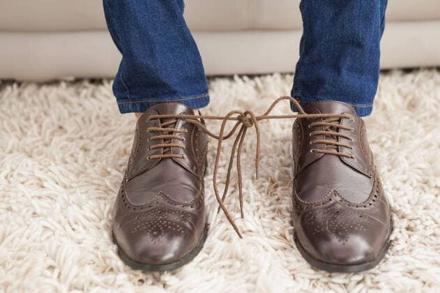 Classy mans shoelaces tied together Classy mans shoelaces tied together at home in the living room, model released, Cape Town, South Africa, 25.06.2014, 412903.jpg, couch, sofa, living room, sitting room, home, house, household, homey, apartment, domicile, abode, lifestyle, leisure, domestic life, rug, carpet, shoelaces, laces, tied, together, prank, aprils fool, brogues, dress shoes, hipster, stylish, classy, elegant Indoors,Day