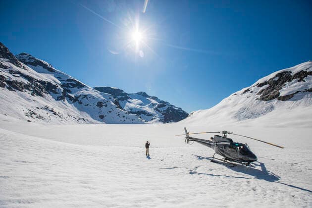 IMAGO Creative: Alternativer Wintersport Man stands next to helicopter, looking out a scenic mountain view. Vancouver, BC, Canada CR_JDIP210406B-480496-01 ,model released, Symbolfoto