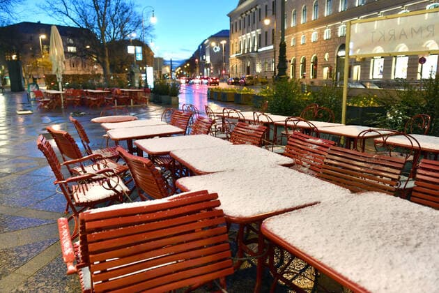 Theme picture Coronavirus Pandemie consequences for the catering trade comes now the bridge Lockdown snow-covered and tied together empty tables and chairs before a restaurant, external catering trade in the Brienner road in Munich on 06 04 2021 after winter onset