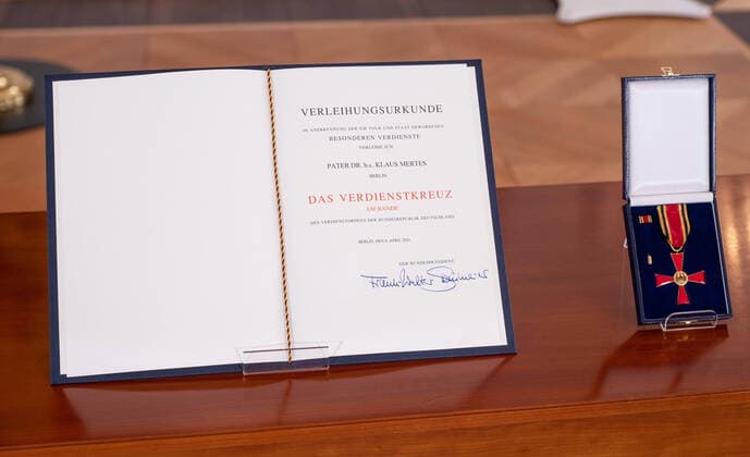 Bundespraesident Frank-Walter Steinmeier hat den gegen sexuellen Missbrauch Engagierten Matthias Katsch und Jesuitenpater Klaus Mertes mit dem Verdienstorden ausgezeichnet (Foto vom 08.04.2021: Verleihungsurkunde und Verdienstkreuz an Klaus Mertens). Durch ihr Wirken sei der Kampf gegen sexuellen Kindesmissbrauch und fuer die Aufklaerung auf der Tagesordnung geblieben, sagte Steinmeier bei der Verleihung der Auszeichnung am Donnerstag in Berlin. Es gebe heute keinen Zweifel mehr daran, dass Missbrauch eine schwere Straftat sei, die strafrechtliche Verfolgung verlange. Solche Faelle duerfen nie wieder nur als innere Angelegenheiten der betroffenen Institutionen, auch nicht der Kirchen, behandelt werden , betonte das Staatsoberhaupt. (Siehe Copyright: epd-bildx xRolfxZoellner EDITORIAL USE ONLY