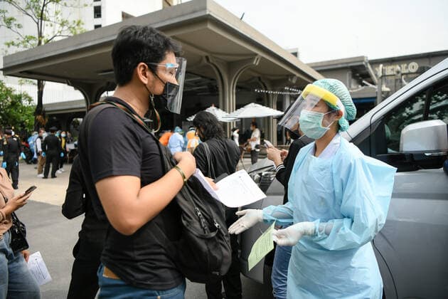 April 8, 2021, Bangkok, Thailand: A health worker wearing a personal protective equipment suite (PPE) assisting a man in a queue for verification of his documents during a swab test drive outside a nightclub in Bangkok..The Ministry of Public Health is set to recommend the closure of night entertainment spots in high-risk areas of Bangkok, in order to deal with the fast-spreading UK variant of the coronavirus. The UK variant is believed to have played a significant role in the spread of the latest cluster of infections detected at entertainment venues across the capital. Bangkok Thailand - ZUMAs197 20210408_zaa_s197_064 Copyright: xAmpholxThongmueangluangx