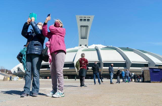 April 8, 2021, Montreal, PQ, Canada: Two women take a self portrait as they wait in line at a COVID-19 vaccination clinic to receive the AstraZeneca vaccine at Olympic Stadium in Montreal, on Thursday, April 8, 2021. Quebecers 55 and over can now get the AstraZeneca vaccine at walk-in clinics across the province. Montreal Canada  - ZUMAc35_ 20210408_zaf_c35_009 Copyright: xPaulxChiassonx