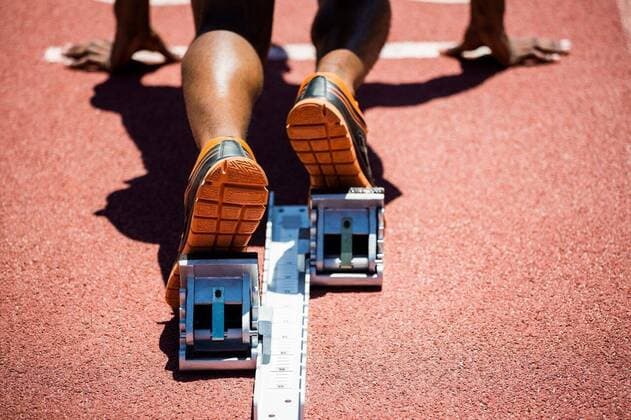 IMAGO Creative: Sport Start-Up Feet of an athlete on a starting block about to run Close-up of feet of an athlete on a starting block about to run, model released, , property released, Cape Town, South Africa, 13.01.2016, 723014.jpg, olympic, olympics, stadium, athlete, athletic, athleticism, sunny, sports shoe, part of, feet, runner, running track, starting block, starting line, start position, ready, kneeling, race, active, fitness, physical, beginning, determination, focused, concentration, competition, challenge, vision, sports, determined 20s, Young Adult, Man, Male, Black, 20-24 Years, Young Men, African Ethnicity Rear view