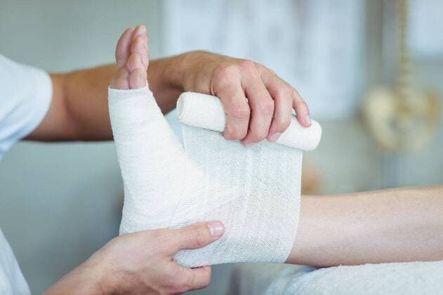 Physiotherapist putting bandage on injured feet of patient Physiotherapist putting bandage on injured feet of patient in clinic, model released, , property released, Cape Town, South Africa, 15.05.2016, 789175.jpg, medical, clinic, hospital, practitioner, doctor, specialist, physio, therapist, physical therapist, physiotherapist, physiotherapy, osteopath, orthopedic, chiropractor, patient, lying, bandaging, wrapping, tying, bandage, gauze, injured, injury, pain, illness, physical injury, leg, foot, ankle, treatment, healing, wellness, care, cure, recovery, health service, healthcare, bodycare, healthcare and medicine, occupation, expertise, profession, professional Indoors,Close-up