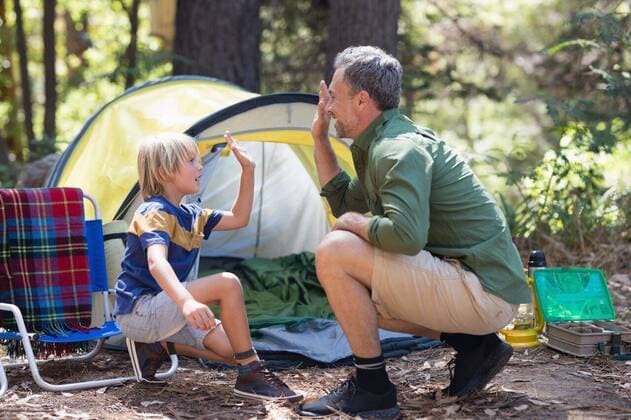 Father and son giving high five by tent at campsite Happy father and son giving high five by tent at campsite, model released, Cape Town, South Africa, 02.03.2017, 974723.jpg, father, son, forest, campsite, holidays, adventure, adventuring, adventurer, hiking, hike, nature, environment, activity, recreation, leisure, lifestyle, exploration, fun, family with one child, one parent, casual, love, together, bonding, weekend activities, tree, tent, crouching, sunlight, chair, field, shoe, high five, cheerful, happy, smiling, excitement, enjoyment Outdoors,Side view,Focus on Foreground,Day,Full length