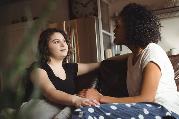 IMAGO Creative: Pride Month 2022, Engagement der Jugendlichen Lesbian couple holding hands while sitting on a couch Lesbian couple holding hands while sitting on a couch at home, model released, , property released, Vancouver, Canada, 06.03.2017, 992996.jpg, home, house, household, homey, apartment, domicile, abode, authentic, real life, domestic life, hold, holding, hands, close, closeness, couch, couple, relationship, adult, lesbian, lesbian couple, girlfriend, look, talk, talking, conversation, looking, homosexual, partner, gay, youth, love, lover, affection, lifestyle, together, leisure, bonding, romance, romantic, sensuality, passion, intimate, milleninial