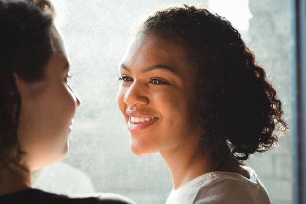 IMAGO Creative: Pride Month 2022, Engagement der Jugendlichen Lesbian couple smiling while having a conversation Close up of lesbian couple smiling while having a conversation, model released, , property released, Vancouver, Canada, 06.03.2017, 993028.jpg, home, house, household, homey, apartment, domicile, abode, authentic, real life, domestic life, smile, smiling, happy, window, bright, sunlight, talk, talking, conversation, interaction, sofa, happiness, light, glass, couple, relationship, adult, lesbian, lesbian couple, girlfriend, homosexual, partner, gay, youth, love, lover, affection, lifestyle, together, leisure, bonding, milleninial