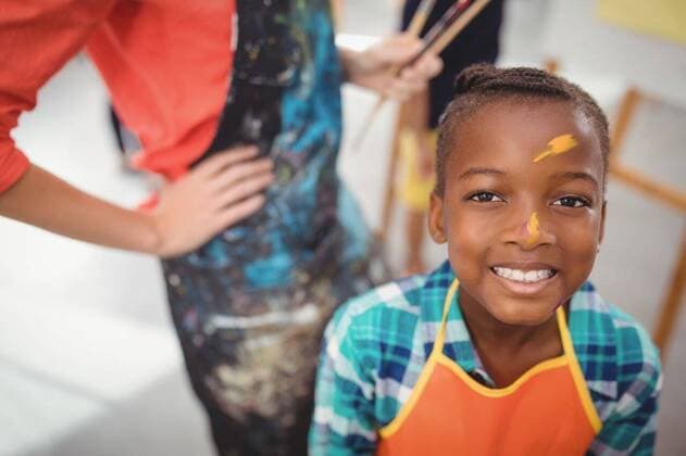 IMAGO Kreativ: Bildung, Kunsterziehung smiling girl with paint on face Portrait of smiling girl with paint on face, model released, , property released, Cape Town, South Africa, 11.03.2017, 993086.jpg, teacher, instructor, drawing teacher, job, occupation, professional, school, classroom, drawing class, student, schoolkid, schoolgirl, elementary, kindergarten, education, knowledge, apron, dirty, messy, standing, smiling, happy, cheerful, enjoyment, fun, joy, painting, paint, watercolor, creative, creativity, hobby, craft, art, art and craft, childhood, cute, innocence, confidence, leisure, lifestyle