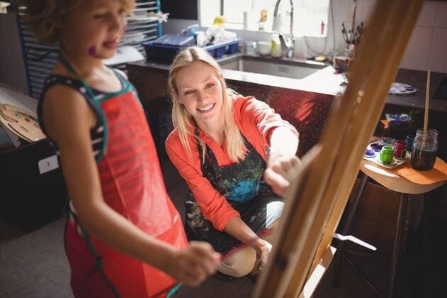 IMAGO Kreativ: Bildung, Kunsterziehung Teacher assisting girl in drawing class Teacher assisting girl in drawing class at school, model released, , property released, Cape Town, South Africa, 11.03.2017, 993104.jpg, teacher, instructor, guidance, job, occupation, drawing teacher, professional, school, classroom, drawing class, student, schoolkid, schoolgirl, elementary, kindergarten, education, knowledge, apron, smiling, happy, cheerful, activity, showing, talking, interacting, communication, learning, practicing, drawing, painting, creative, creativity, paintbrush, canvas, easel, watercolor, wooden, brush, hobby, assistance, craft, art, art and craft, childhood, innocence, together