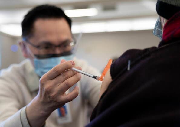 April 10, 2021, Richmond, BC, Canada: Dr. E. Kwok administers a COVID-19 vaccine to a recipient at a vaccination clinic run by Vancouver Coastal Health, in Richmond, B.C., Saturday, April 10, 2021. Richmond Canada  - ZUMAc35_ 20210410_zaf_c35_038 Copyright: xJonathanxHaywardx