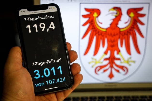 Coronavirus in Germany Covid 19 Dashboard of the Robert Koch Institute DEU, Germany, Brandenburg, 11 04 2021 The 7-day incidence for the state Cases last 7 days 100 000 p.e. is displayed on an iPhone, with the state coat of arms in the background