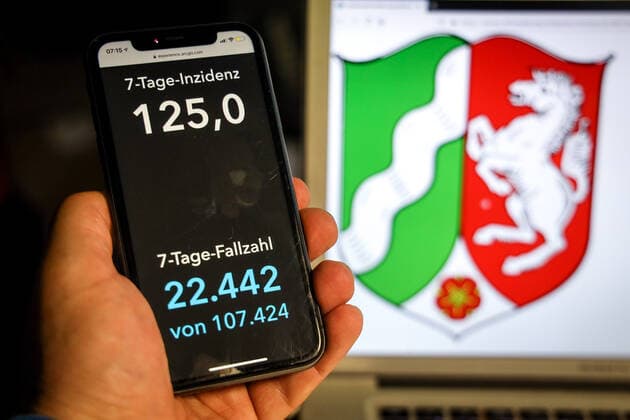 Coronavirus in Germany Covid 19 Dashboard of the Robert Koch Institute DEU, Germany, North Rhine Westphalia, 11 04 2021 The 7-day incidence for the state Cases last 7 days 100 000 PE is displayed on an iPhone, with the state coat of arms in the background.