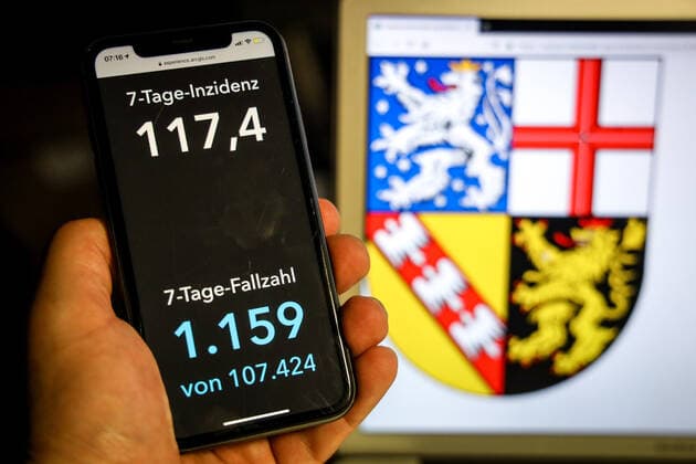 Coronavirus in Germany Covid 19 Dashboard of the Robert Koch Institute DEU, Germany, Saarland, 11 04 2021 The 7-day incidence for the state Cases last 7 days 100 000 PE is displayed on an iPhone, with the state coat of arms in the background.
