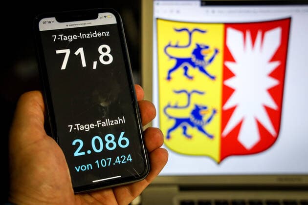 Coronavirus in Germany Covid 19 Dashboard of the Robert Koch Institute DEU, Germany, Schleswig Holstein, 11 04 2021 The 7-day incidence for the state Cases last 7 days 100 000 PE is displayed on an iPhone, with the state coat of arms in the background.