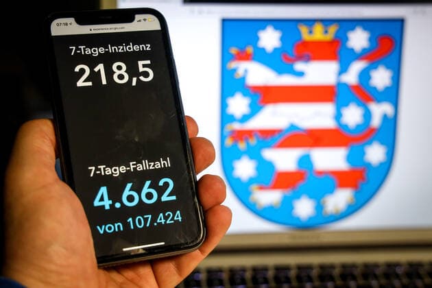 Coronavirus in Germany Covid 19 Dashboard of the Robert Koch Institute DEU, Germany, Thuringia, 11 04 2021 The 7-day incidence for the state Cases last 7 days 100 000 PE is displayed on an iPhone, with the state coat of arms in the background.