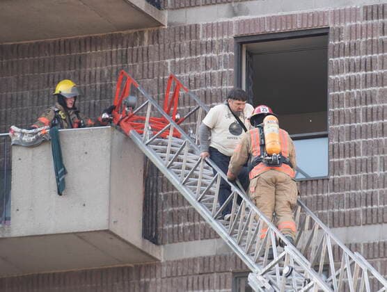 April 11, 2021, Montreal, PQ, Canada: Firefighters helps a man out of an apartment building following a fire in Montreal, Sunday, April 11, 2021. Montreal Canada  - ZUMAc35_ 20210411_zaf_c35_011 Copyright: xGrahamxHughesx