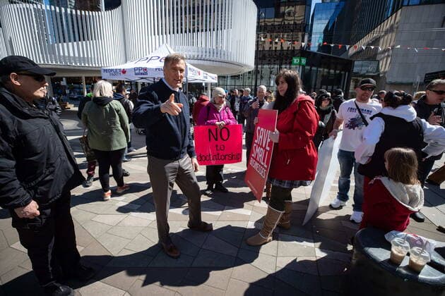 April 11, 2021, Vancouver, BC, Canada: People s Party Leader Maxime Bernier, centre left, speaks with a supporter during an Open Up Canada rally and march held by people opposed to public health guidelines in place to curb the spread of COVID-19, in Vancouver, on Sunday, April 11, 2021. Vancouver Canada - ZUMAc35_ 20210411_zaf_c35_063 Copyright: xDarrylxDyckx
