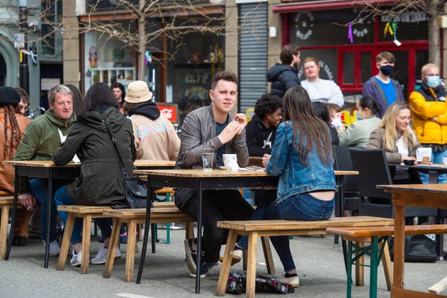 People eat and drink at tables outside a restaurant on Stevenson Square in city centre Manchester on 12 April 2021. Customers have returned to the High Street on Monday as non-essential retailers in England and Wales reopened after more than three months of lockdown restrictions due to the Covid-19 pandemic. Manchester Greater Manchester England City Centre  Copyright: xMattxWilkinsonx