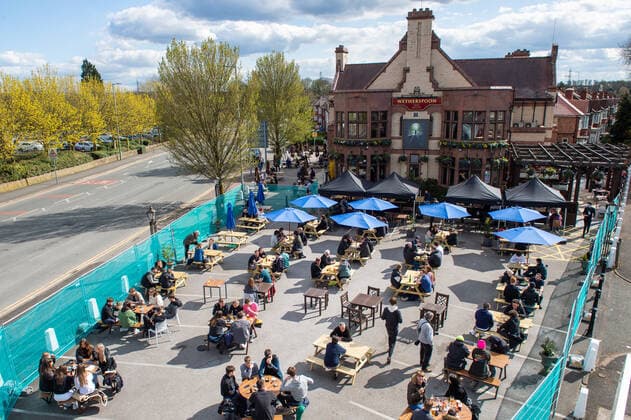 People drink outside the JD Wetherspoon Gateway pub in East Didsbury, south Manchester on 12 April 2021. Customers have returned to the High Street on Monday as non-essential retailers in England and Wales reopened after more than three months of lockdown restrictions due to the Covid-19 pandemic. Manchester Greater Manchester England City centre  Copyright: xMattxWilkinsonx