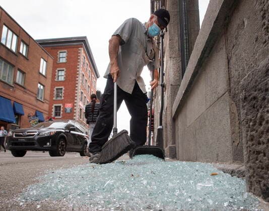 April 12, 2021, Montreal, PQ, Canada: Carlos Londono cleans up broken glass after last night s anti-COVID-19 curfew riot, Monday, April 12, 2021 in Montreal. Montreal Canada  - ZUMAc35_ 20210412_zaf_c35_004 Copyright: xRyanxRemiorzx