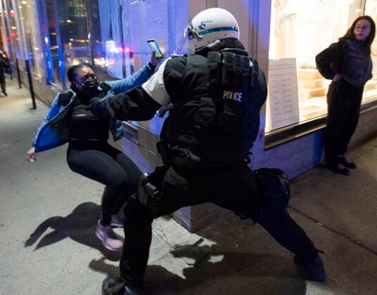 April 12, 2021, Montreal, PQ, Canada: Police try and detain a woman as anti-curfew protests continue for a second night Monday, April 12, 2021 in Montreal. Montreal Canada  - ZUMAc35_ 20210412_zaf_c35_095 Copyright: xRyanxRemiorzx