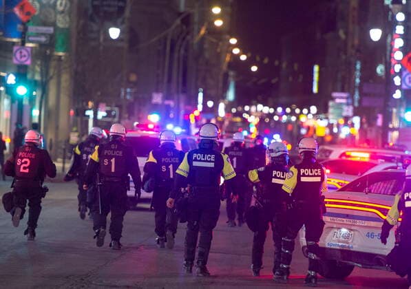 April 12, 2021, Montreal, PQ, Canada: Police move down Saint Catherine street as anti-curfew protests continue for a second night Monday, April 12, 2021 in Montreal. Montreal Canada  - ZUMAc35_ 20210412_zaf_c35_100 Copyright: xRyanxRemiorzx