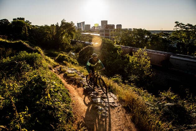 Mountain biker at sunrise with Richmond skyline in the background. United States, Virginia, Richmond CR_KYLA210413-691141-01 ,model released, Symbolfoto