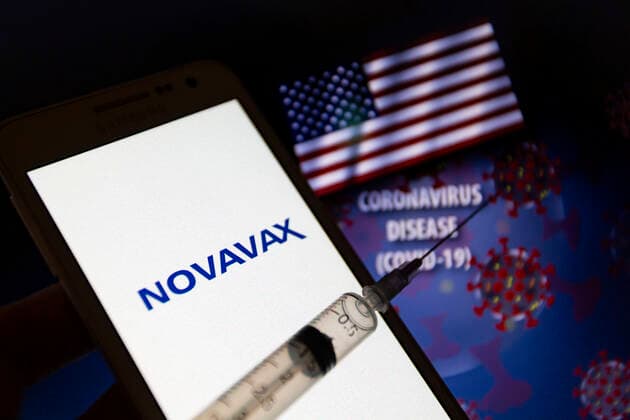 February 1, 2021, Asuncion, Paraguay: Illustration photo of logo of Novavax, Inc. (Nasdaq: NVAX), a biotechnology company, seen displayed on smartphone behind a syringe with needle in front of waving flag of the United States, the words coronavirus disease (COVID-19) and visual representation of virus. Novavax announced on Jan 28 that NVX-CoV2373, its protein-based COVID-19 vaccine candidate, met the primary endpoint, with a vaccine efficacy of 89.3%, in its Phase 3 clinical trial conducted in the United Kingdom Asuncion Paraguay - ZUMAc217 20210201_zip_c217_001 Copyright: xAndrexM.xChangx