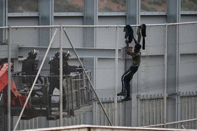Two agents approach a migrant who tries to jump the fence that separates Ceuta from Morocco, on April 13, 2021, in Ceuta, (Spain). In the early hours of the morning of Tuesday, April 13, a group of at least 60 migrants tried to jump the fence to enter Spanish territory, a fact that has caused the intervention of agents of the Moroccan Security Forces and the Civil Guard to prevent their entry into the country. According to police sources have informed LagenciaEP , the jump has not caused any injuries and although several people have managed to climb the outer fence of the autonomous city, none has managed to access Spanish territory. 13 APRIL 2021;CEUTA;JUMPING;FENCE;MIGRANTS Antonio Sempere LagenciaEP 04 13 2021 Ceuta Ceuta Spain Copyright: xAntonioxSemperex 3641214