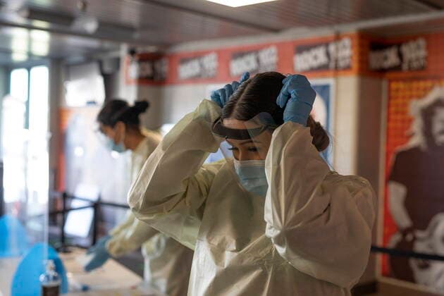 April 15, 2021, Saskatoon, SK, Canada: STC volunteer Montana Ledoux puts on PPE at the Saskatoon Tribal Council run vaccination clinic inside SaskTel centre in Saskatoon, Sask., on Thursday, April 15, 2021. Saskatoon Canada  - ZUMAc35_ 20210415_zaf_c35_052 Copyright: xKaylexNeisx