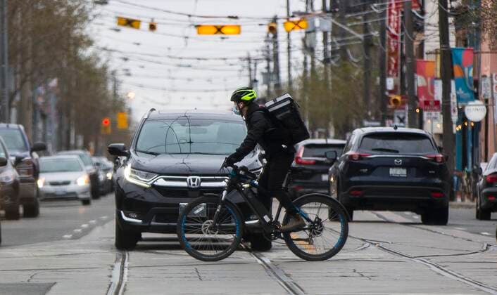 (210416) -- TORONTO, April 16, 2021 -- A man wearing a face mask rides a bicycle across a street in Toronto, Canada, on April 16, 2021. On Friday afternoon, Canada reported 6,771 new cases of the COVID-19, bringing the cumulative total to 1,103,441, including 23,535 deaths, according to CTV. (Photo by Xinhua) CANADA-TORONTO-COVID-19-CASES ZouxZheng